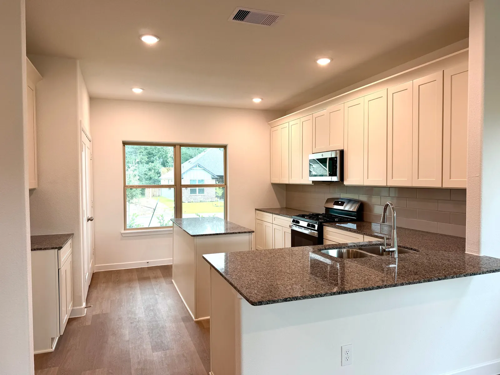 Kitchen with granite counters and island at 11830 Serena's Song Drive, Willis, TX