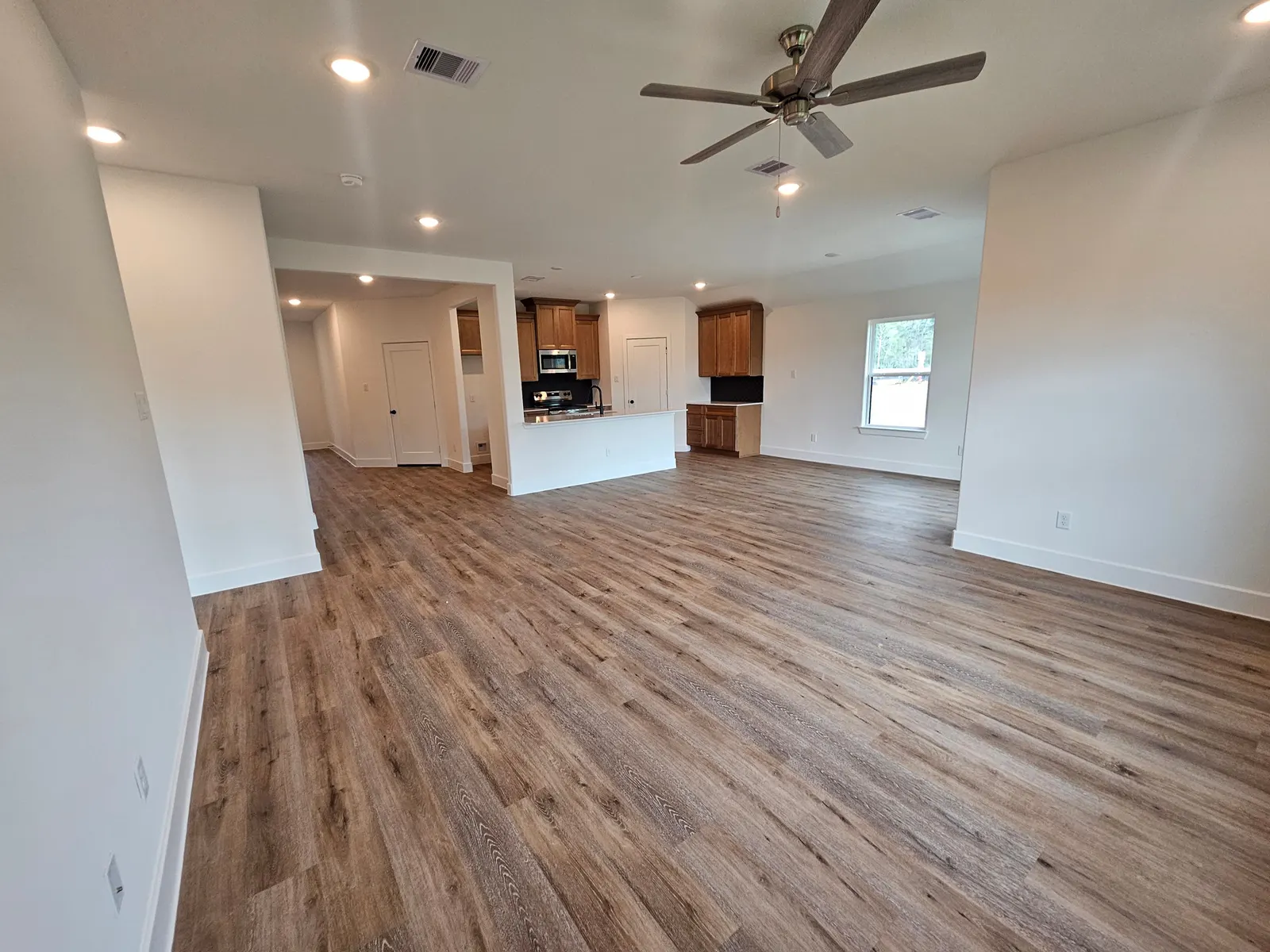 Open concept living and kitchen with ceiling fan at 10727 Crockett Meadows, Conroe, TX