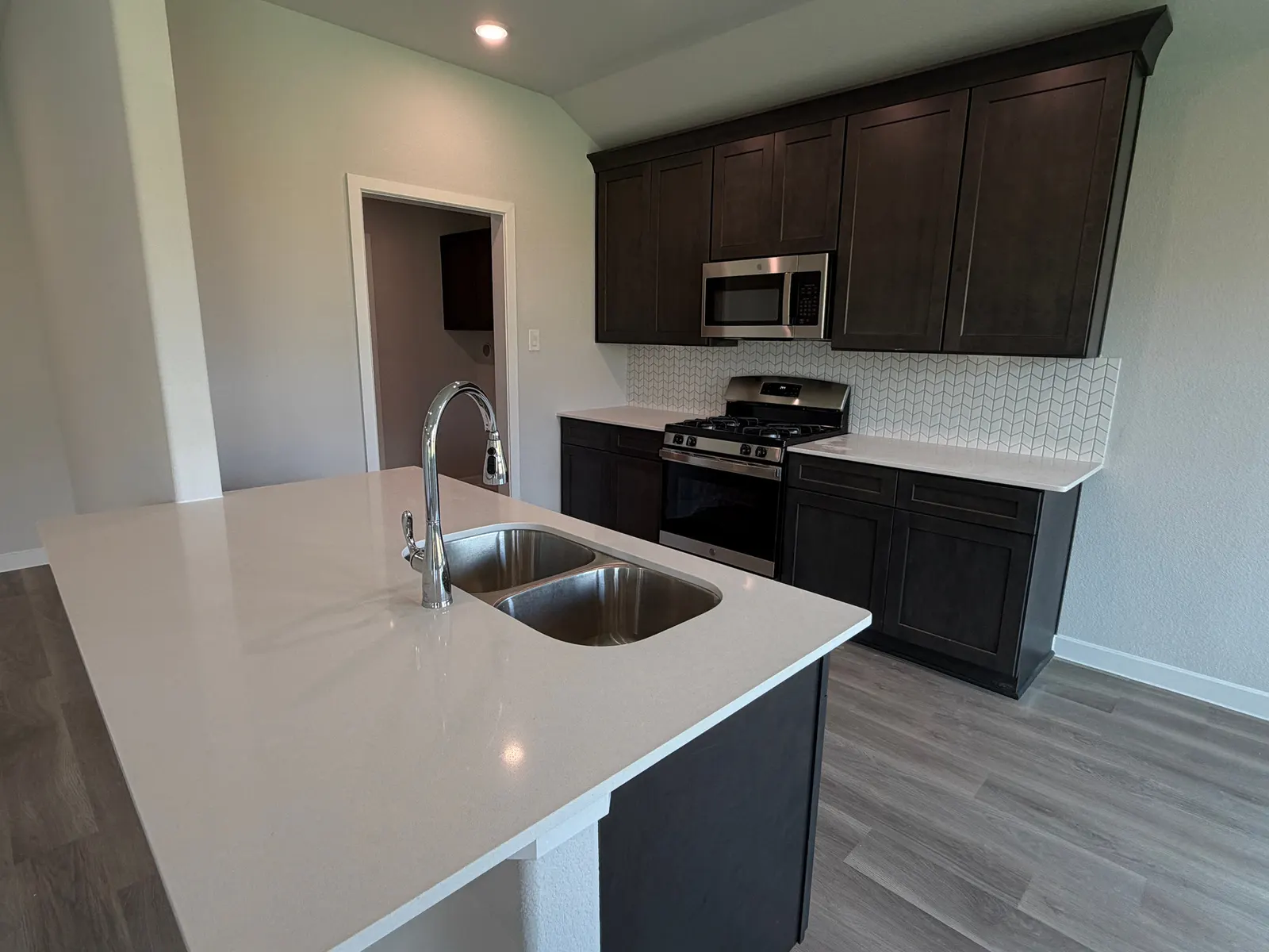 Kitchen with island and dark cabinets at 11858 Serena's Song Drive, Willis, TX