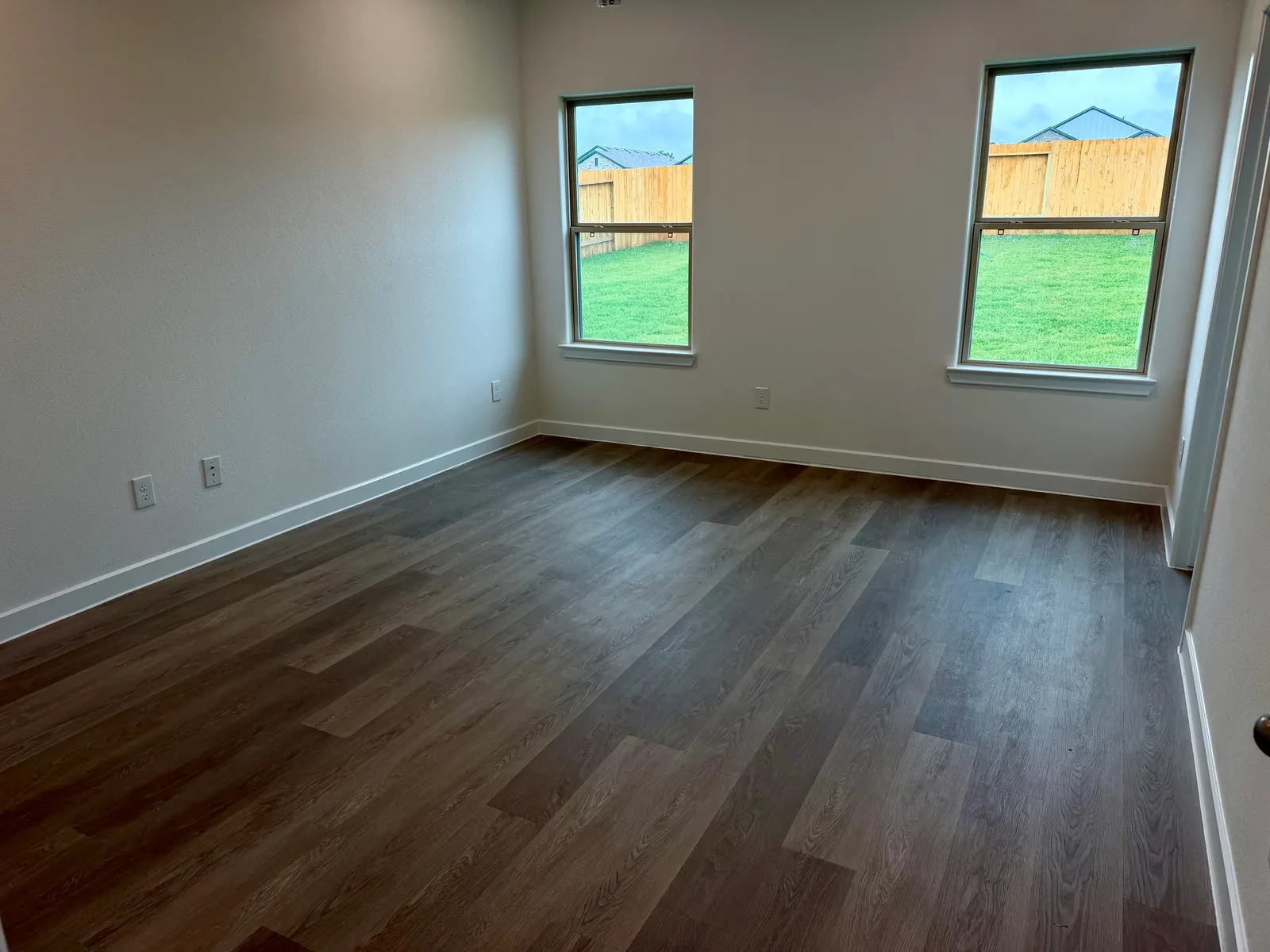 Living and dining area with wood look flooring at 11830 Serena's Song Drive, Willis, TX