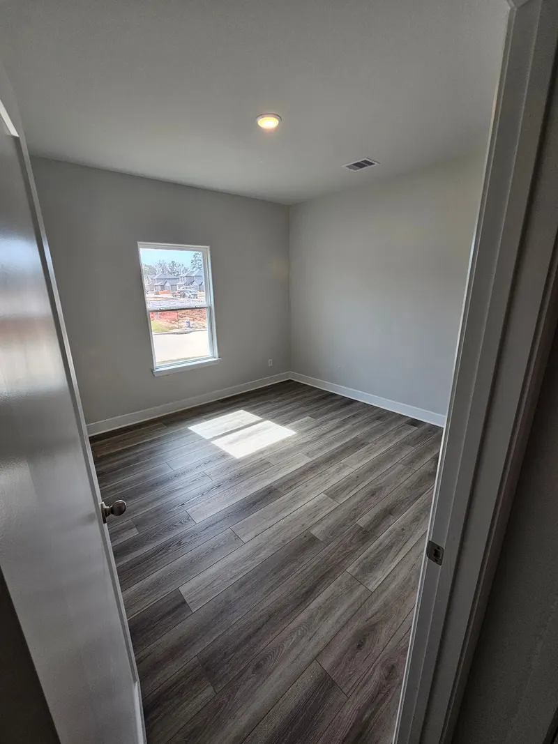 Bedroom with window and wood look flooring at 11803 Serena's Song Drive, Willis, TX