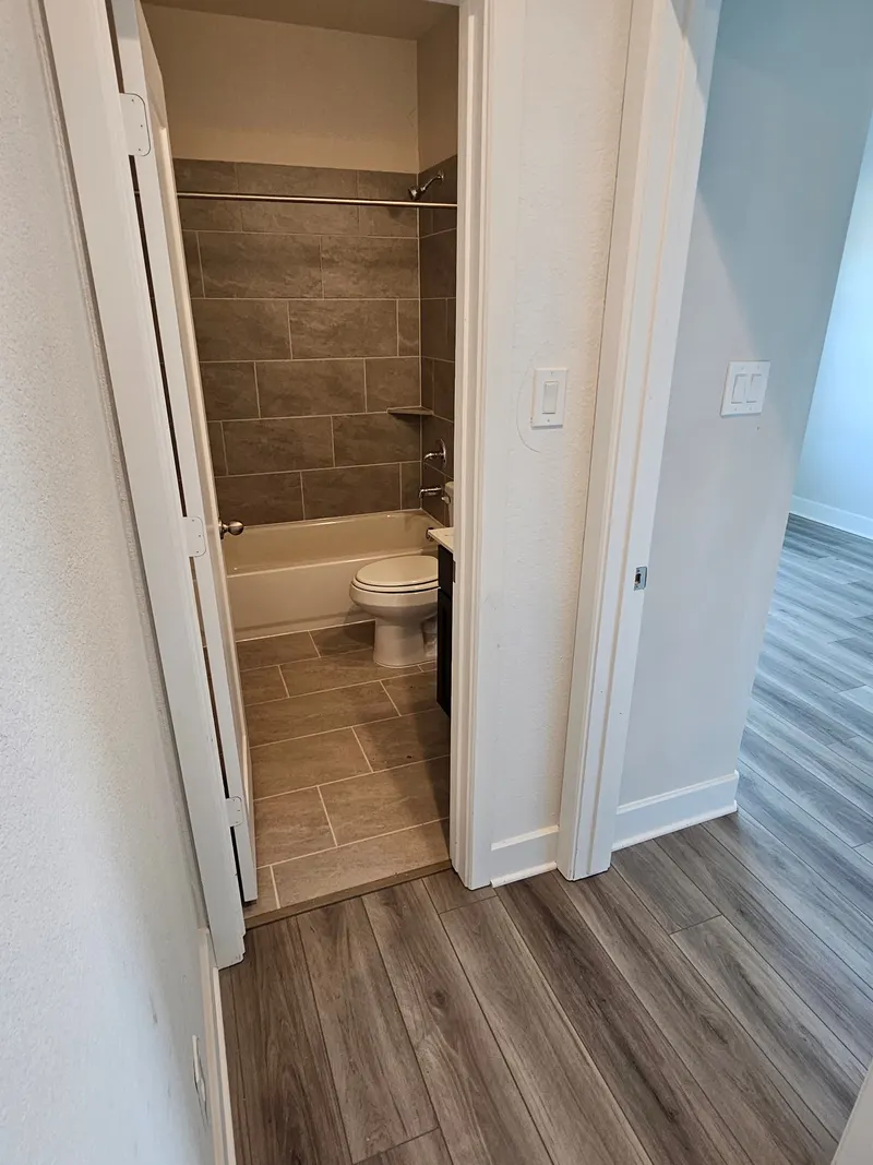 Bathroom with toilet and tile surround at 11803 Serena's Song Drive, Willis, TX