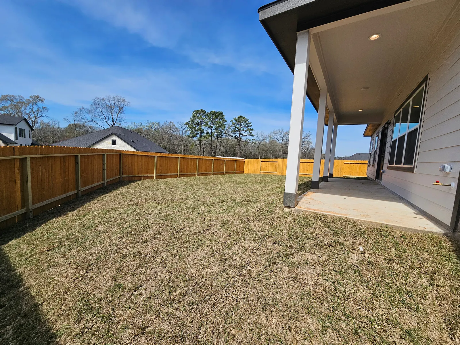 Covered back patio and yard at 11803 Serena's Song Drive, Willis, TX