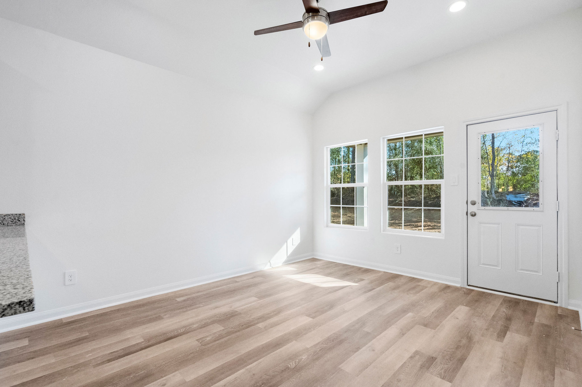 Living room with windows and rear door at Cedar Crossing by Alta Homes