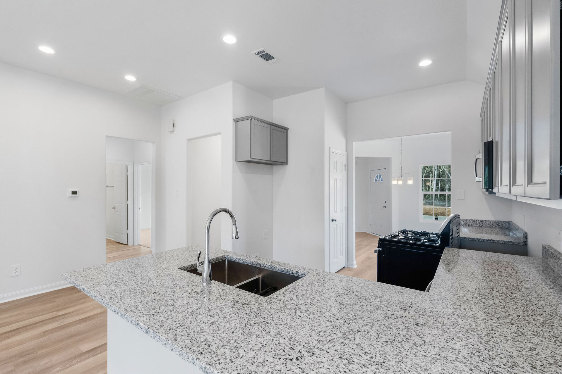 Kitchen with granite peninsula and sink at Cedar Crossing by Alta Homes