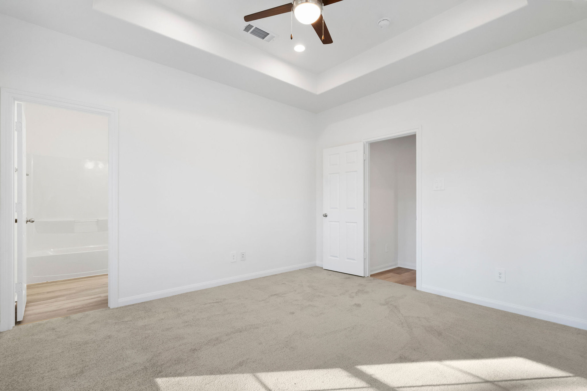 Living and dining area with tray ceiling at Cedar Crossing by Alta Homes