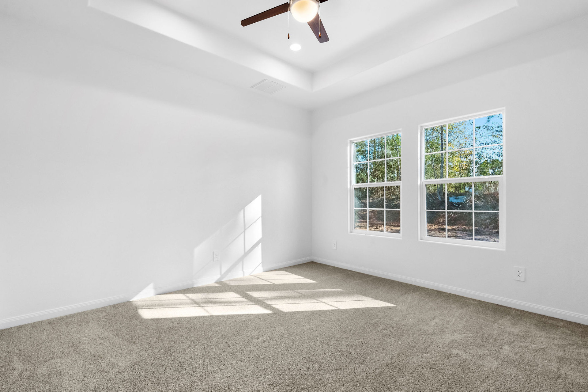 Carpeted bedroom with two windows at Cedar Crossing by Alta Homes